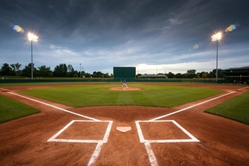 Baseball field with a pitcher on the mound under a cloudy sky