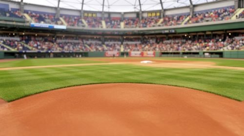 Baseball field with green grass, dirt, and a stadium full of fans