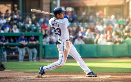 Baseball player Reyes swings bat, wearing jersey number 23, during a game