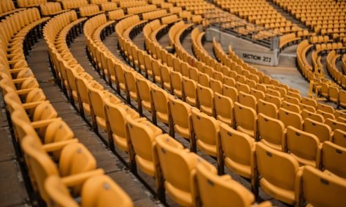 Rows of empty yellow stadium seats in a curved formation