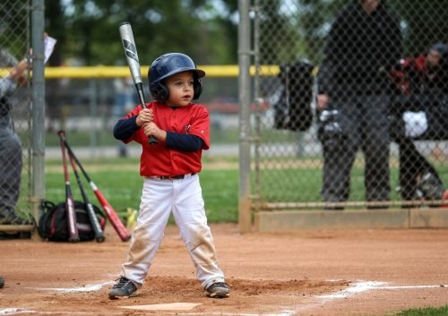 Young baseball player in uniform, holding a bat, ready to hit